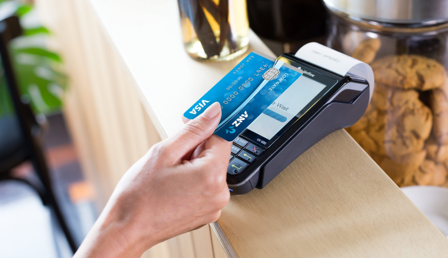 Woman paying with her ANZ Visa in a cafe