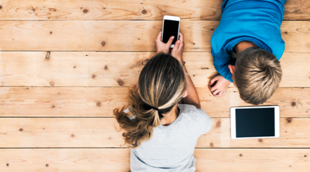 Handsome Smiling Freelancer Showing Finished Project on Digital Tablet to a Colleague in Coffee Restaurant