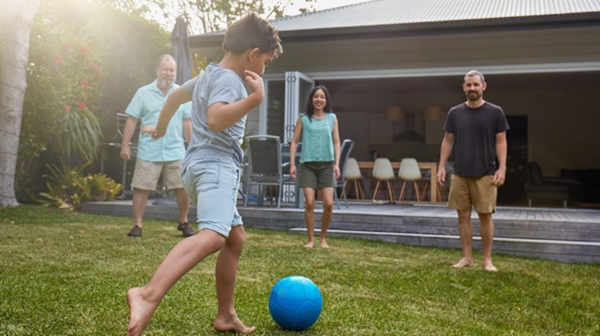 A family playing with a ball in a backyard